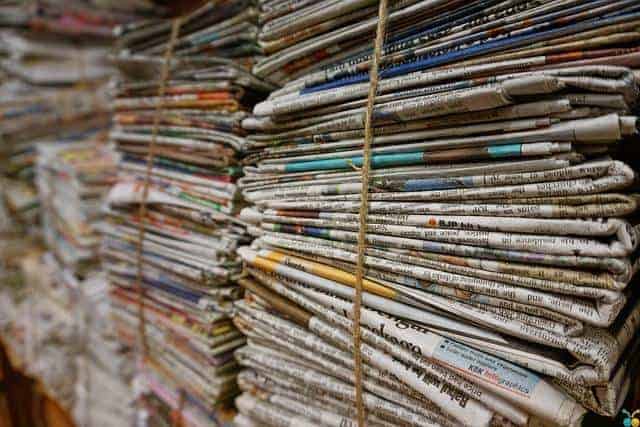 A stack of newspapers on a shelf.