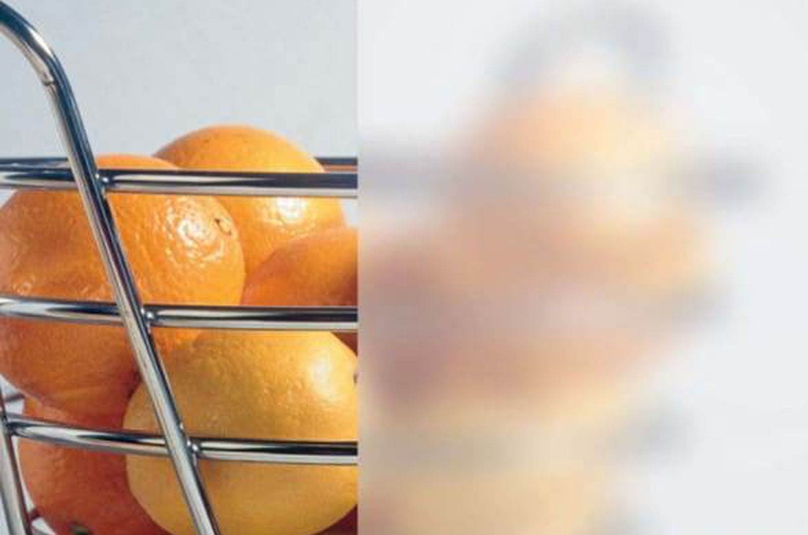 A metal basket full of oranges.